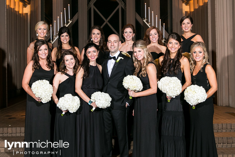 groom and bridemaids in black with white flowers