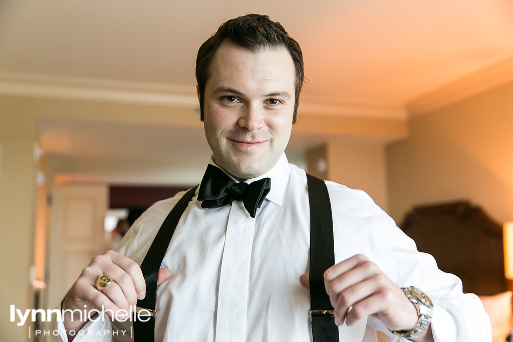 groom in tux and suspenders wedding day